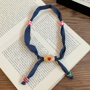 Detail of denim fabric texture with colorful heart beads on an open book background