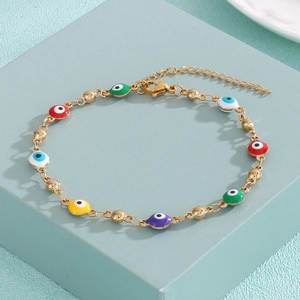 Detail of colorful enamel evil eye charms on a gold bead chain with adjustable clasp