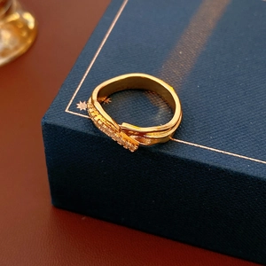 Vue rapprochée d'une bague irrégulière dorée avec zircons sur un écrin de bijoux sombre