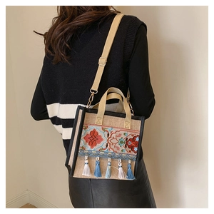 Detailed view of ethnic embroidery tote bag with tassel charm and adjustable strap