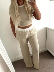 Detail of khaki ribbed knit short sleeve top and high waist wide leg trousers