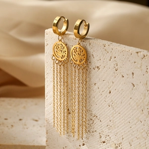 Golden Tree of Life hoop earrings with delicate chain tassels on textured stone
