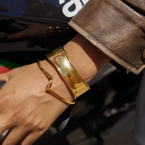 Gros plan de deux bracelets en acier inoxydable plaqué or 18k portés au poignet