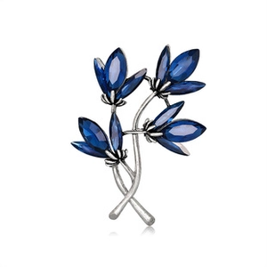 Close-up of floral brooch with silver metal and blue marquise cut rhinestones
