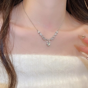 Close-up of a zircon flower pendant necklace on neck showing fine jewelry details