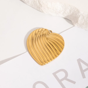 Vue macro du pendentif cœur doré avec texture ondulée 3D sur fond blanc minimaliste