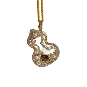 Golden gourd-shaped necklace featuring tiger eye stone and pearls on white background