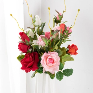 Close-up of artificial red, pink and white roses with realistic petals and green leaves