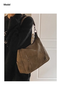Brown suede tote bag with double zippers and metal ring detail shown on a shoulder