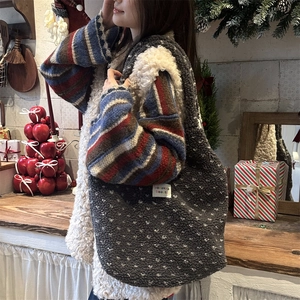 Winter heart pattern plush tote bag in dark grey fleece shown in a cozy indoor setting