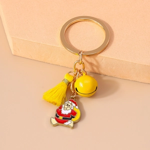 Detail of Christmas keychain with yellow bell tassel and enamel Santa Claus charm