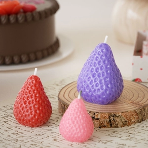 Candele profumate a forma di fragola rossa, rosa e viola su base in legno rustico