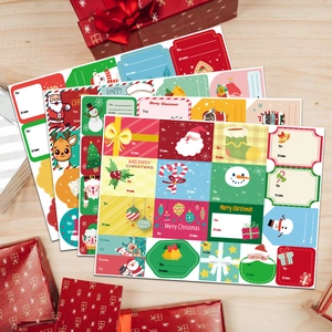 Christmas gift labels with To From tags on wood table with festive red gift boxes
