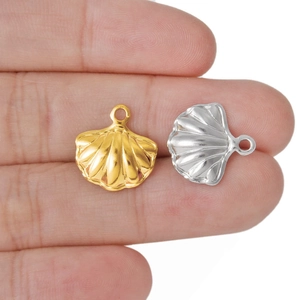 Shell shaped 304 stainless steel pendants in gold and silver held on fingers