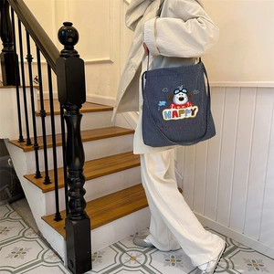 Close-up of navy blue striped canvas bag featuring cute dog embroidery and Happy logo