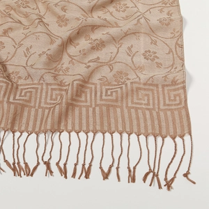Dettaglio ravvicinato di motivi floreali jacquard beige e frange su una sciarpa vintage
