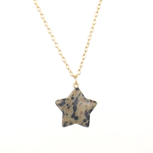 Close-up of Dalmatian stone star pendant on a delicate gold chain necklace