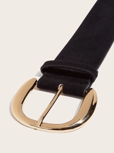 Close-up of a matte black suede belt featuring a large polished gold metal buckle detail