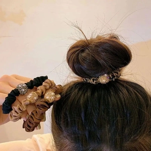 Detailed view of velvet bow scrunchies in four colors with sparkling diamond-studded beads