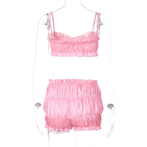 Detailed view of pink satin two-piece set with ruffled edges and gathered texture fabric