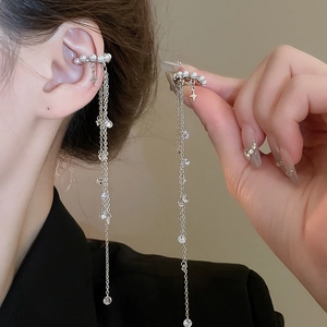 Detail of silver pearl ear cuff with long tassel chains and sparkling star charms