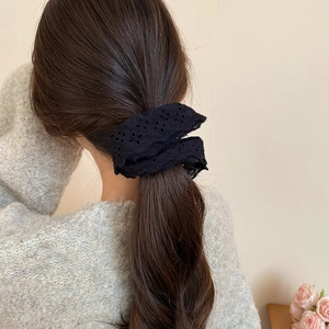 Detailed view of a black double-layered hollow lace scrunchie on a ponytail