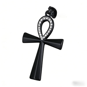 Polished black Ankh cross pendant with sparkling white cubic zirconia stones on white base