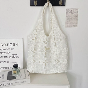 Detailed macro view of white floral lace tote bag featuring intricate geometric embroidery
