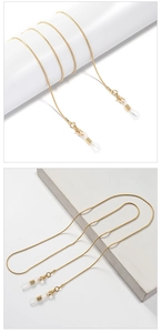 Detail of gold snake chain eyewear strap with lobster clasps and silicone loops