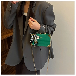 Green box handbag with wave texture, gold handle, and polka dot scarf shown on model