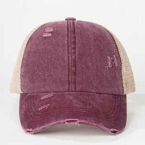 Close-up of distressed cotton trucker hat with torn details and breathable mesh back