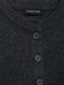 Detailed close-up of dark grey knit cardigan neckline with ribbing and matte buttons