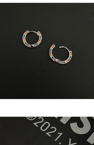 Macro shot of silver rainbow hoop earrings featuring multi-color micro-set zircon stones
