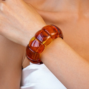 Macro detail of amber acrylic geometric elastic bracelet with warm honey texture