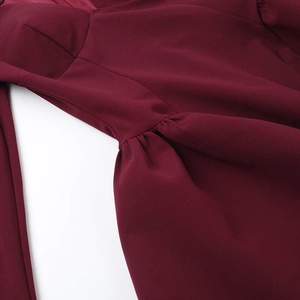 Detail of burgundy dress featuring pleated waist and high-quality neckline stitching