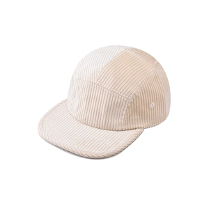 Detail of cream corduroy 5-panel cap showing textured fabric and side eyelets
