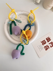 Gros plan de pendentifs tulipes en crochet faits main avec du fil coloré et silicone