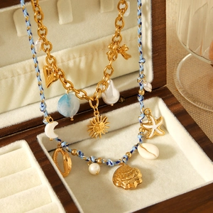 Gold layered necklace with sun and starfish charms in a luxury jewelry display box