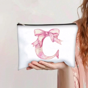 Handheld view of a white canvas makeup bag featuring a pink watercolor letter C print