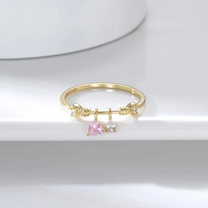 Detail of gold-plated S925 ring with pink heart and white teardrop cubic zirconia