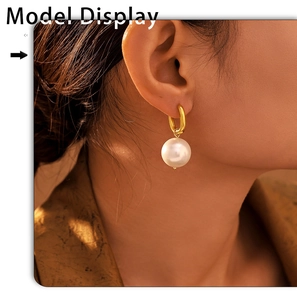 Close-up of model wearing U-shaped golden stainless steel earrings with large white pearls