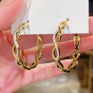 Golden wavy hoop earrings with twisted lines and sparkling cubic zirconia stones