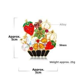 Detail of colorful fruit basket brooch with rhinestones and enamel on white background