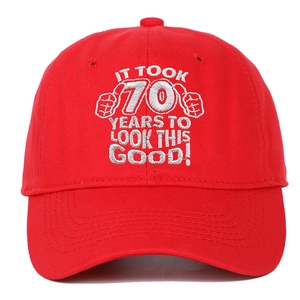 Detail of red cotton baseball cap with 70th birthday embroidery and two fist icons