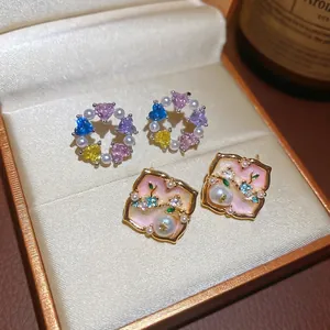 Elegant zircon heart and pearl stud earrings displayed on a luxury jewelry box