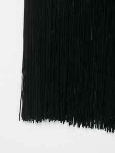 Détail montrant les franges noires denses et les glands d'une robe de vacances ajustée