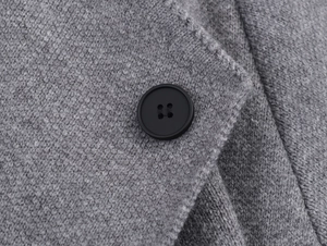 Detailed close-up of premium grey knit fabric texture with a classic black resin button