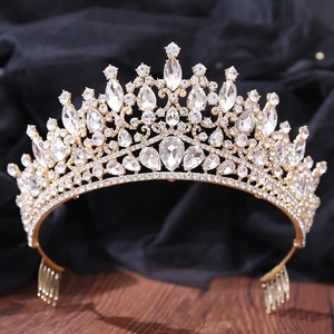 Close-up of golden baroque bridal crown with sparkling rhinestones on dark background