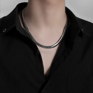 Men's silver embossed Cuban link chain necklace in hip-hop style on model's neck