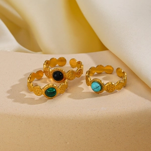 Three gold adjustable bohemian rings with turquoise and obsidian stones on display